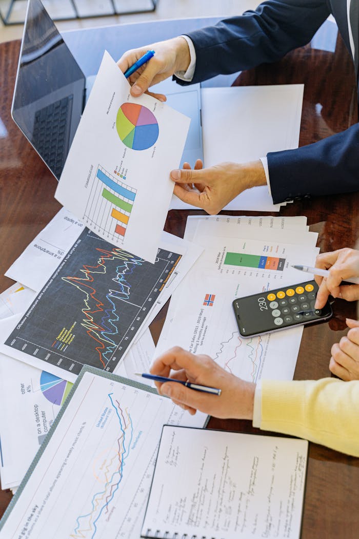 creative Business professionals analyzing financial charts and graphs during a meeting.