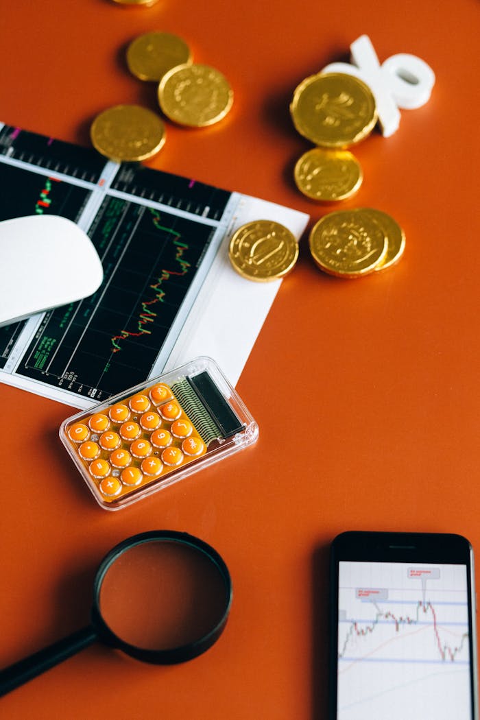 Services-03 Stock market and financial analysis setup with calculator, graphs, and gold coins.